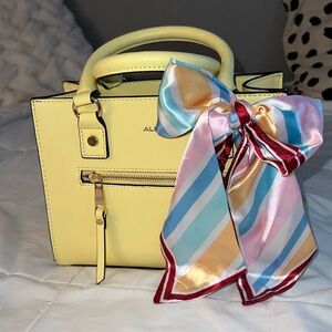 brand new, small - medium purse, yellow with pastel colored bow detail.